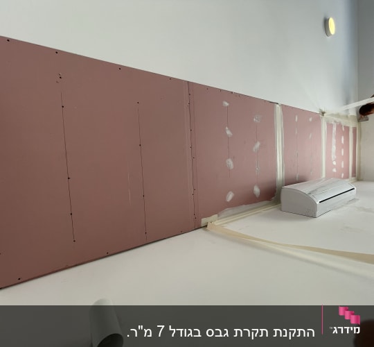קיר גבס ורוד עם חיבורים ומזגן מותקן
